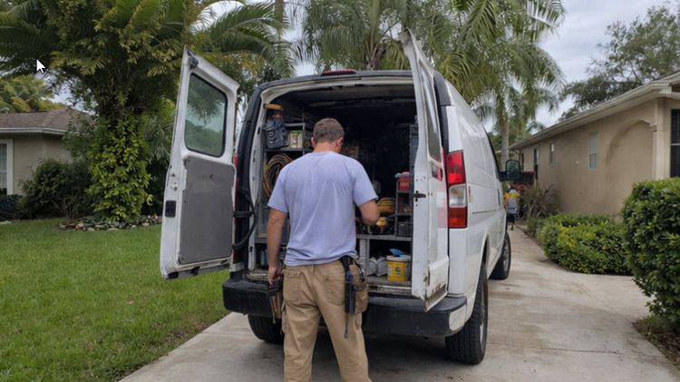 Florida trade contractor at the rear of a work van loaded with tools, equipment, and supplies in front of a Jacksonville-area home